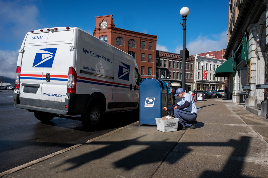 Letter Carrier Sasa Maksimovic retrieves mail from a collection box in Rutland, VT.