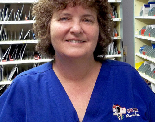 Smiling postal worker stands in workroom