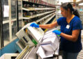 Woman works on sorting machine inside postal plant