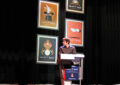Illusionist stands on stage in front of stamps