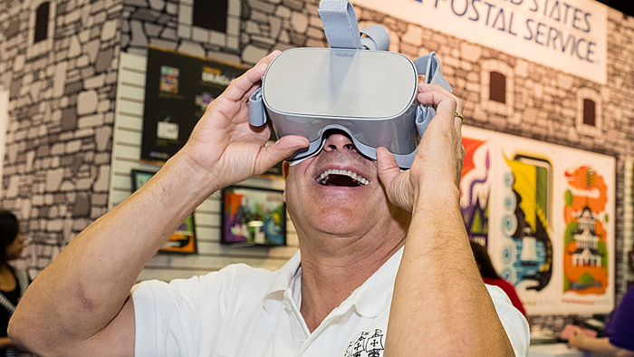 Man uses a virtual reality device at the Dragons stamp event