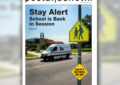 Magazine cover that shows postal truck on street near school traffic sign