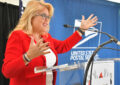 Smiling woman gestures at podium