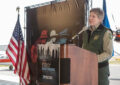 Smiling woman stands at podium