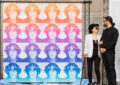 Yoko Ono gazes adoringly at Sean Lennon near stamp poster