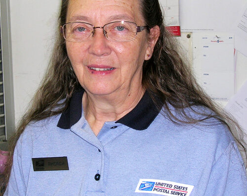 Smiling woman wearing postal uniform