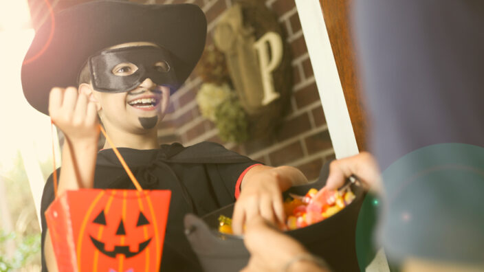 Child in Halloween costume with candy