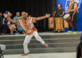 Man in African garb performs lively dance