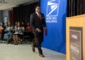 Smiling man crosses stage