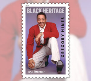 Stamp showing a smiling Gregory Hines kneeling with raised tap shoe