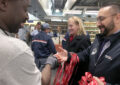 Two men shake hands in postal workroom