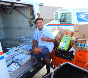 Sam Sarmiento, a letter carrier at Hillcrest Station in San Diego, loads a delivery vehicle