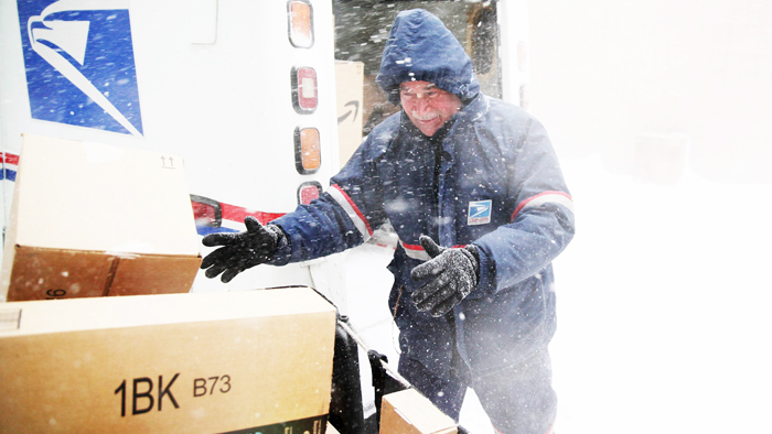 Postal service employee loads a delivery vehicle