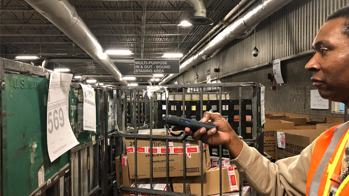 Postal employee with mail in a processing plant