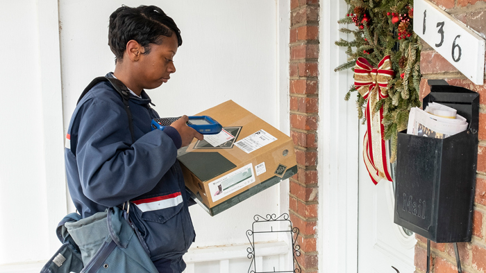Postal worker scans a package