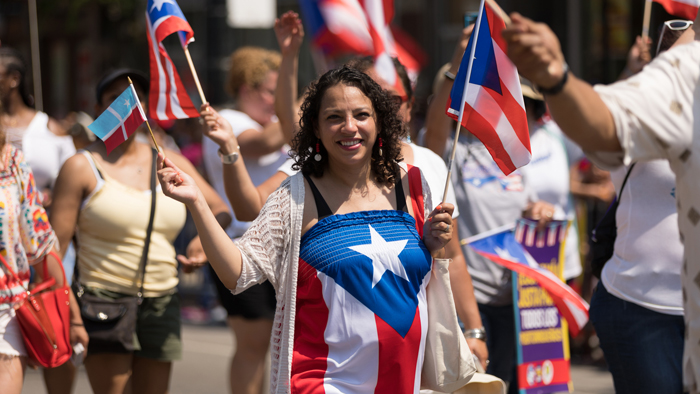 A woman waving a Puerto Rican flag