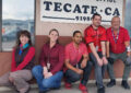 Five people wear red near Post Office sign