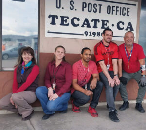 Five people wear red near Post Office sign