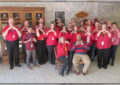 Large group of people make heart signs with hands