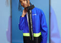 Model wears blue USPS-themed jacket