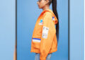 Model wears orange USPS-themed jacket