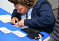 Postal worker applies handstamp to envelope