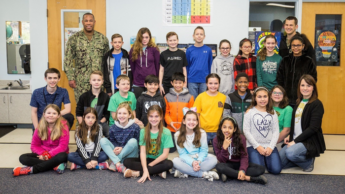 Fifth grade class pose with U.S. Navy Capt.