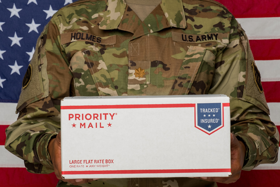 Army soldier holding Priority Mail box