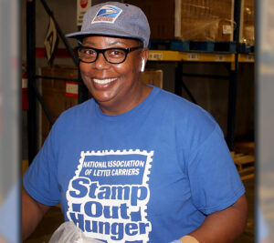 Smiling woman wears Stamp Out Hunger T-shirt