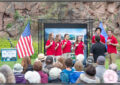 Young people in red shirts sing