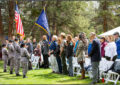 Young people in military-style uniforms hold flags