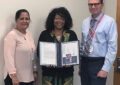 Smiling woman displays certificate next to man, woman