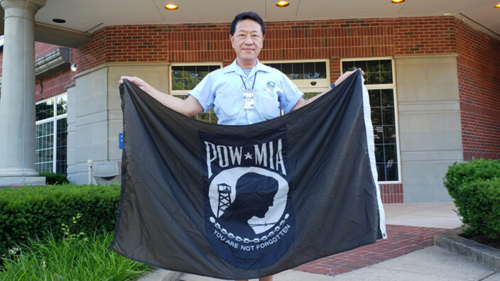 Man holding POW flag