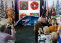 People stand on stage with oversized stamp image