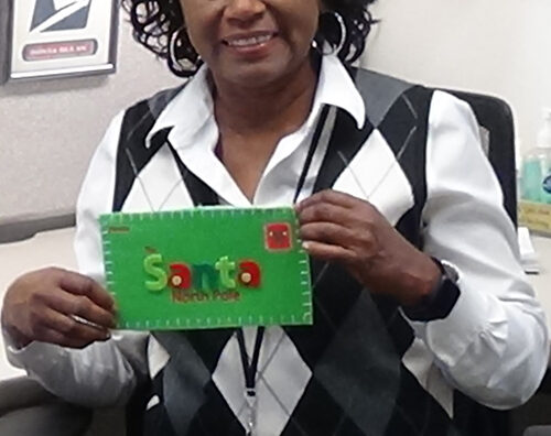 Postal employee holds holiday greeting card.