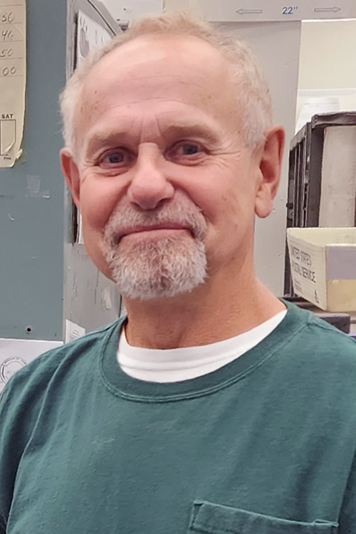 Smiling man standing in post office workroom