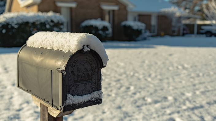 A residential mailbox covered in snow