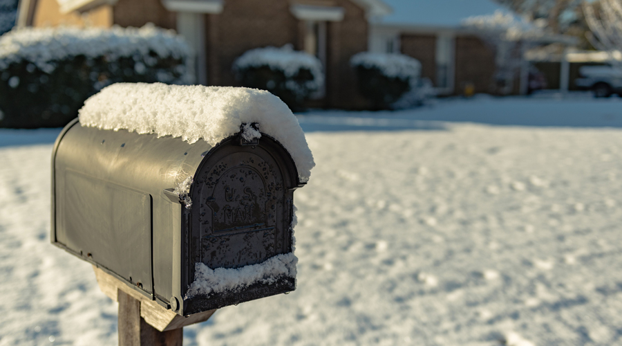 A residential mailbox covered in snow