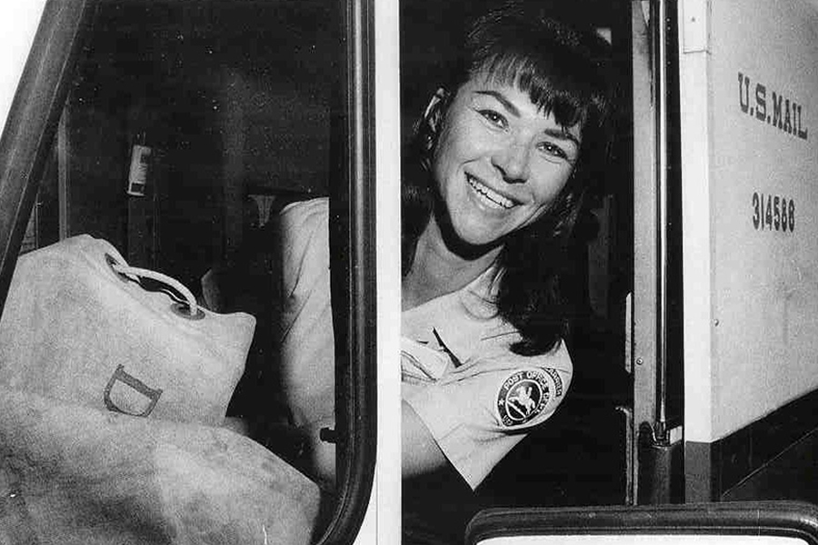 Female letter carrier delivering mail in a U.S. mail truck in 1968