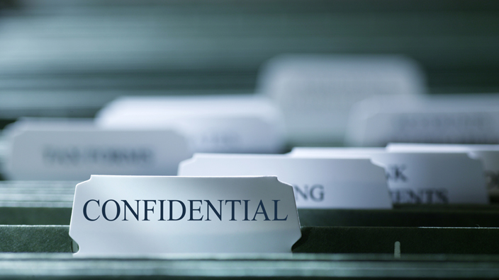 A file folder with the word "confidential" printed on the tab