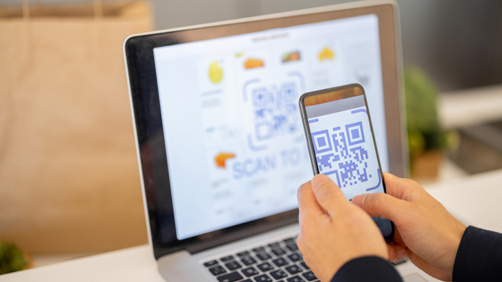Hands use a smartphone to scan a QR code