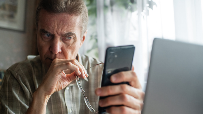 A man reading a suspicious message on mobile phone