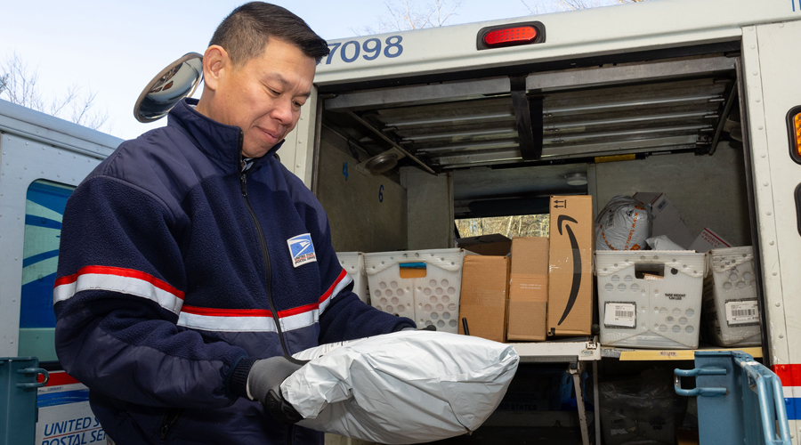 A letter carrier prepares to deliver a package
