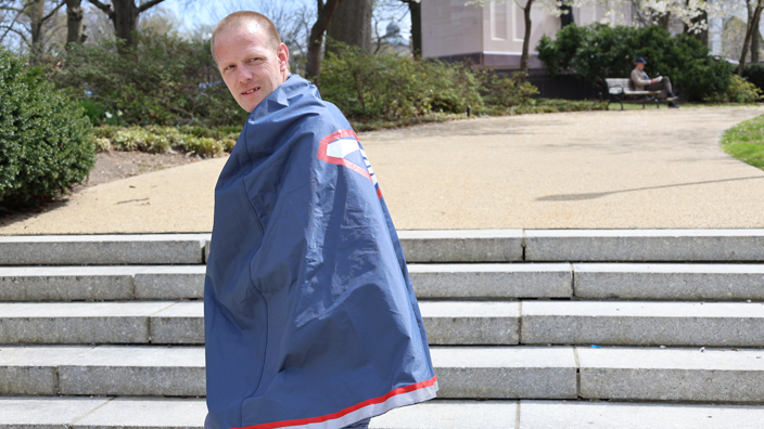 Letter Carrier Timothy Martin wearing a postal-themed cape