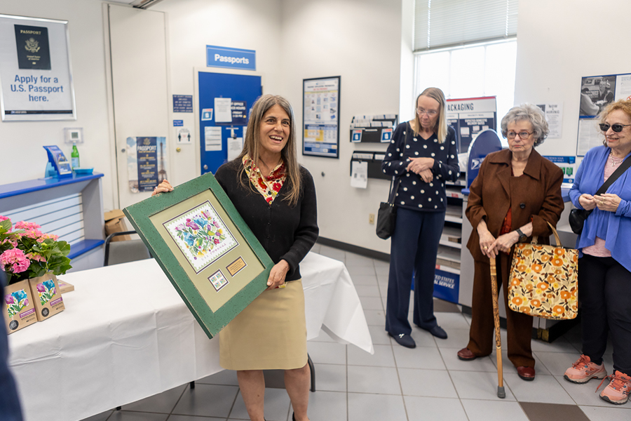 Artist Kim Parker displays her illustrations appearing on the Celebration Blooms and Wedding Blooms stamps to customers at the Huntington, NY, Post Office.
