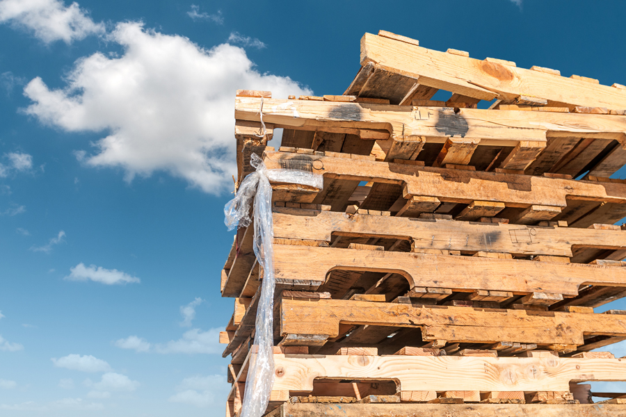 A stack of wooden pallets against the backdrop of a blue sky