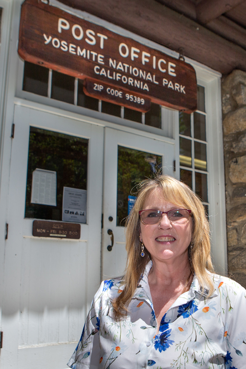 Postmaster Ellen Damin stands outside the Yosemite, CA, Post Office.