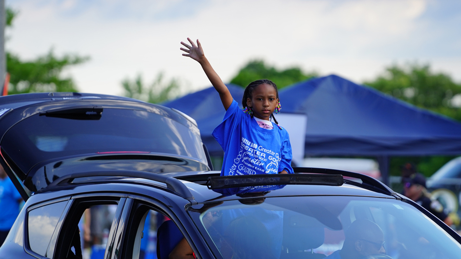A participant waves to the crowd during a Juneteenth parade in Milwaukee in 2021.