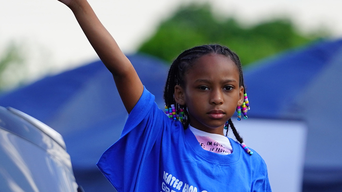 A participant waves to the crowd during a Juneteenth parade in Milwaukee in 2021.
