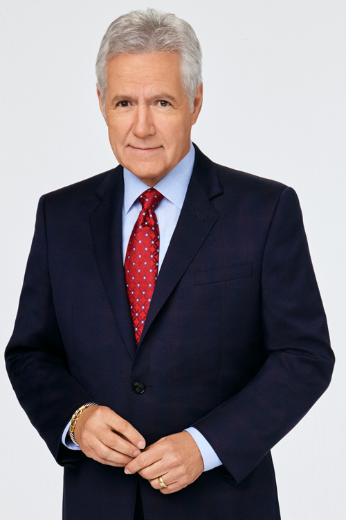 A photo of Alex Trebek wearing a dark jacket and red tie